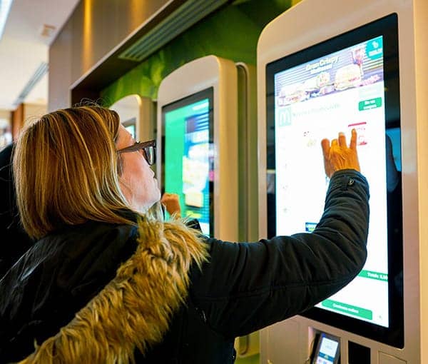 Ordenando comida rápida desde un kiosco de auto-pedido.